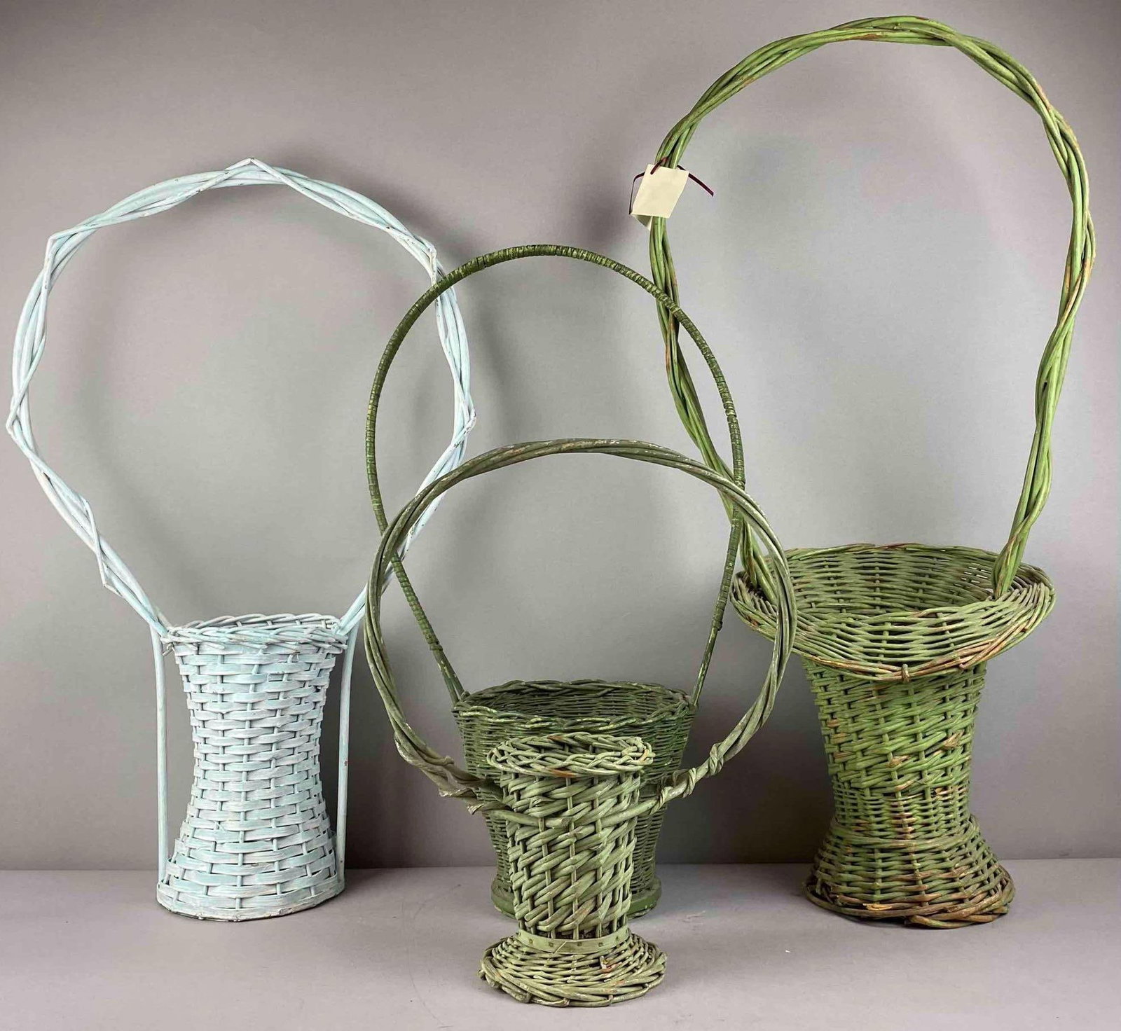 Group of 4 Vintage Wicker Flower Baskets: Largest measures 31 inches tall.