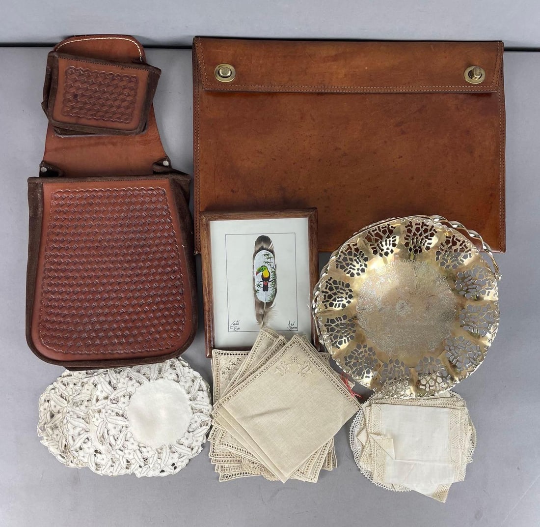 Group of Embroidered Linens and More: Includes leather saddlebag and attache, painted Costa Rica feather, attach? measures 11 1/4 inches x 16 1/4 inches