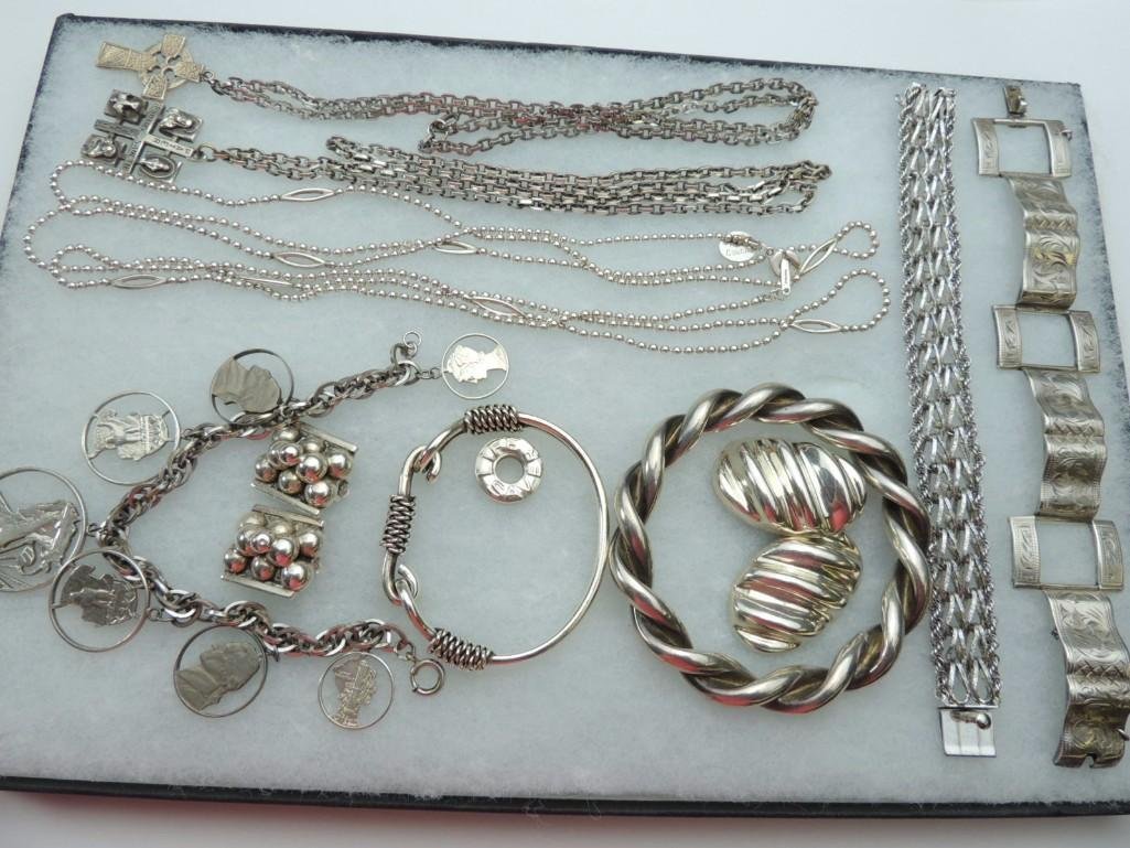 Group of 11 Silver Jewelry Items: 294.1 Grams, 2 Link Bracelets, 2 Hard Bangle Bracelets, 1 Cut Out Coin Bracelet,1 Celtic Cross, 1 Religious Medal, 1 Anne Klein Couture Chain, 2 Pr. Clip Earrings and 1 Life Saver Charm