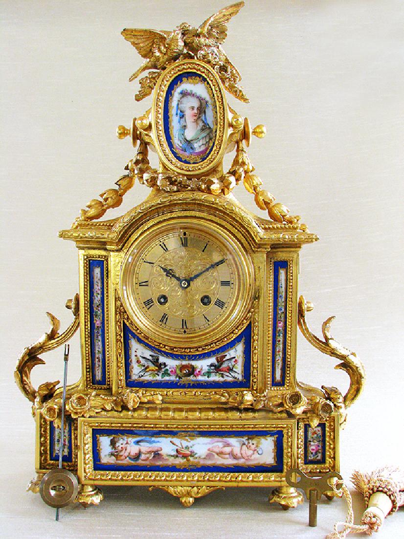 Antique Gilt Ormolu and Sevres Clock: The clock has a gold ormolu case with original gold gilt finish, blue hand painted sevres porcelain depicting a portrait on top and cherubs and leaves. The movement is top quality French two train 8 d
