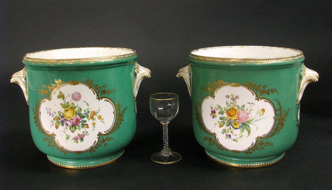 Pair of Green-Ground Sevres-Style Wine Cooler: A pair of English porcelain green-ground Sevres-style bottle coolers (seaux a bouteilles), mid 19th century, possibly Coalport, decorated with quatrefoil panels of flowers. Height: 7 inches Diameter: 
