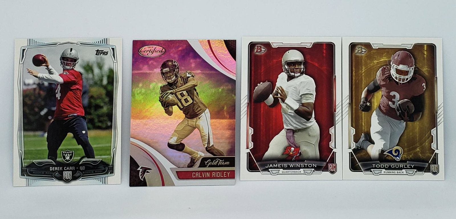 LOT OF 4 NFL FOOTBALL STAR ROOKIE CARDS: 2018 CALVIN RIDLEY ROOKIE GOLD TEAM, DEREK CARR LAS VEGAS RAIDERS 2014 BOWMAN ROOKIE CARD, 2014 TODD GURLEY & JAMEIS WINSTON ROOKIES