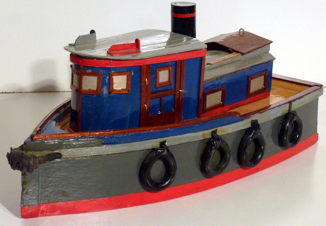 Nice Folk Art hand made Tugboat: This is a nice folky handmade tugboat. It is well done and very detailed and painted in a variety of colors including red, black, blue, brown, and gray. The hatch cover slides open. This boat is about