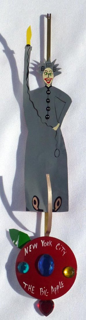 Folk art Statue of Liberty N. Y. Big Apple.: This is a folk art Statue of Liberty cut out of metal mounted on what probably was a large button of some sort. The button is inset with costume jewelry. The large round bottom is painted New York Cit