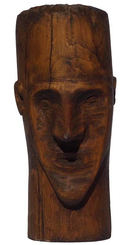 187 Folk Art wood carving of the head of a man: This wood carving is the head of a man; probably done in hard pine. It is 7 1/2" high by 3" wide, by 4 1/2" deep to the tip of his pointy nose. On the base are impressed the letters T, W, and H. The s