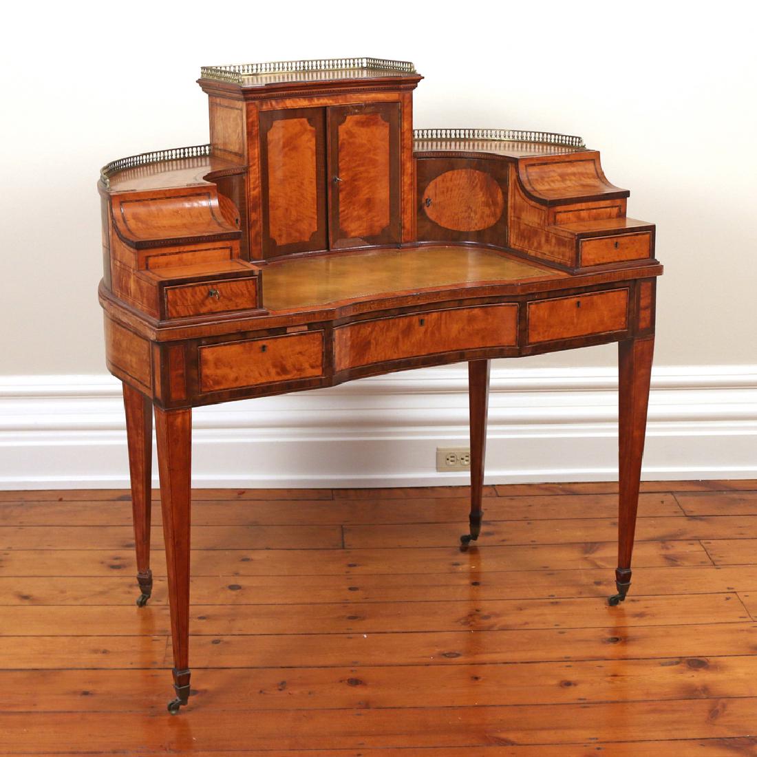 INLAID SATINWOOD CARLTON HOUSE DESK: 19th Century, England, curved back with a stepped superstructure having a 3/4 gallery, central cabinet with letter slots, leather writing surface, and various compartments, the frieze with three drawe