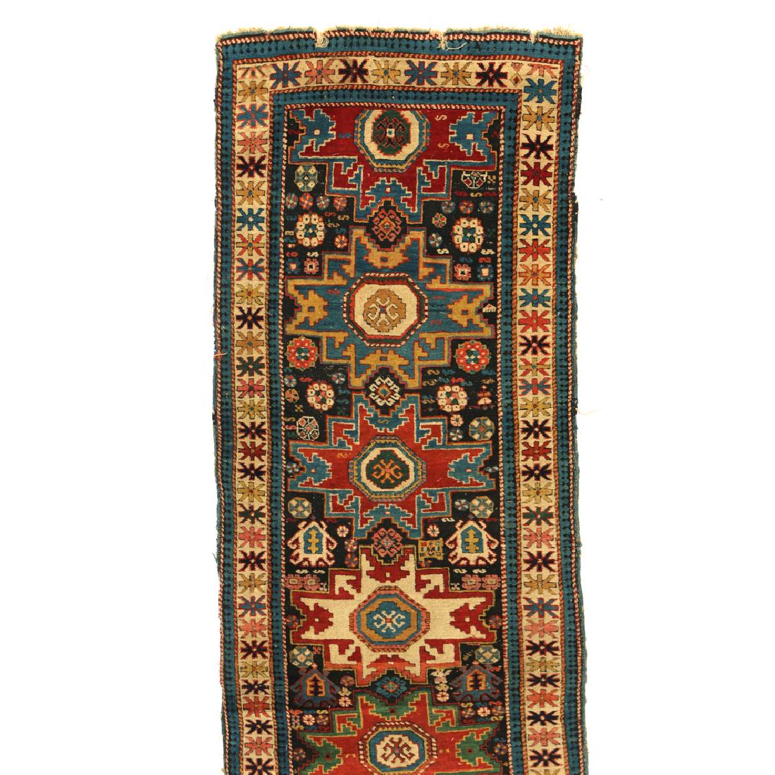 LESGHI-STAR LONG RUG: late 19th/early 20th Century, probably Daghestan, Caucuses, with a row of Lesghi stars in various colors on a black ground with white borders, woven in thick lustrous wool pile h. 10ft 2in. w. 2ft 8in