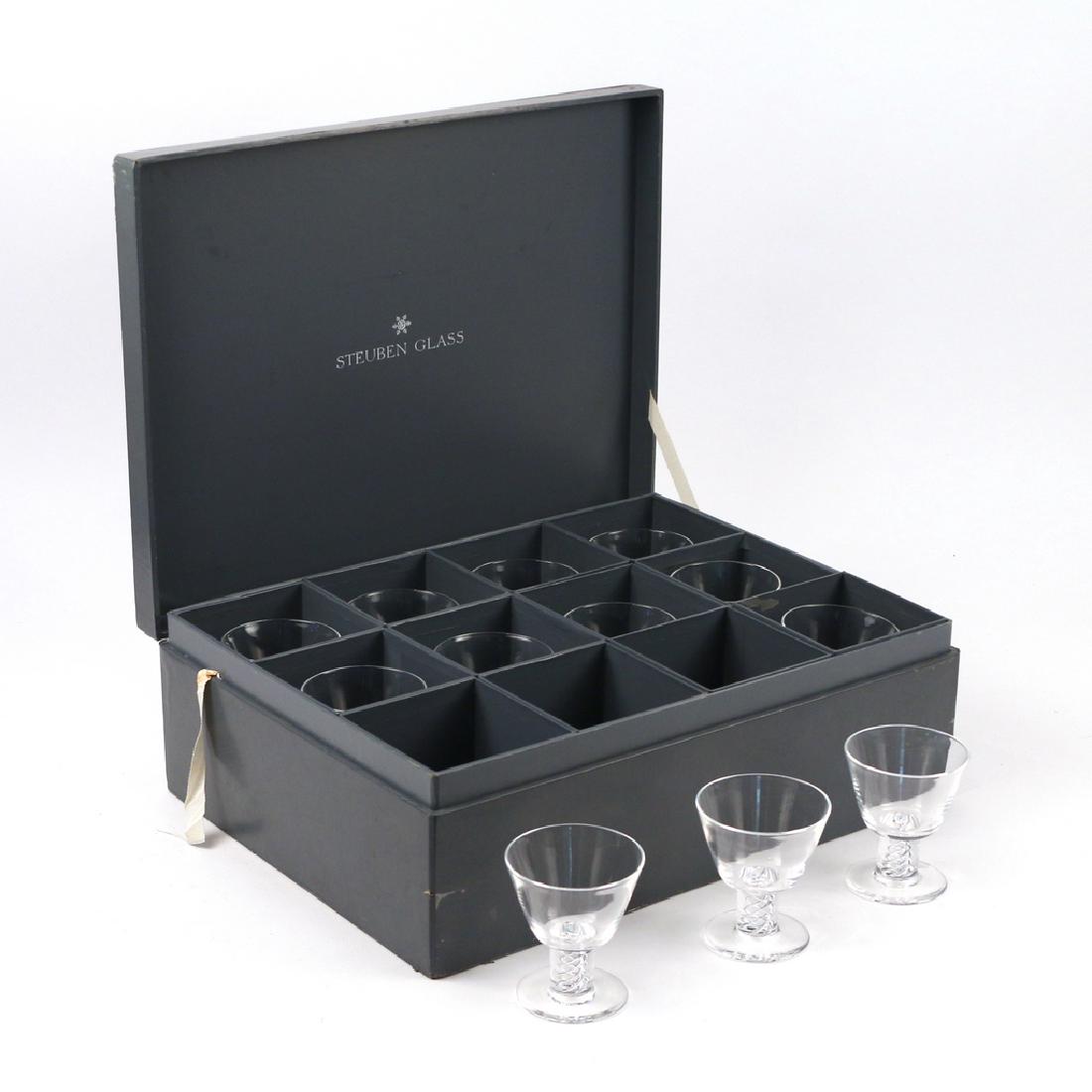 (12pc) BOXED STEUBEN 'AIR TWIST' GLASSES: 12 cocktail glasses with twisted blown stems, each signed Steuben" on pontil, in a Steuben velvet bag, in a compartmentalized Steuben lidded box (h. 5-1/2 x w.17-1/4 x d. 13 in.) h. 3-3/4 w. 3-1/4 in.
