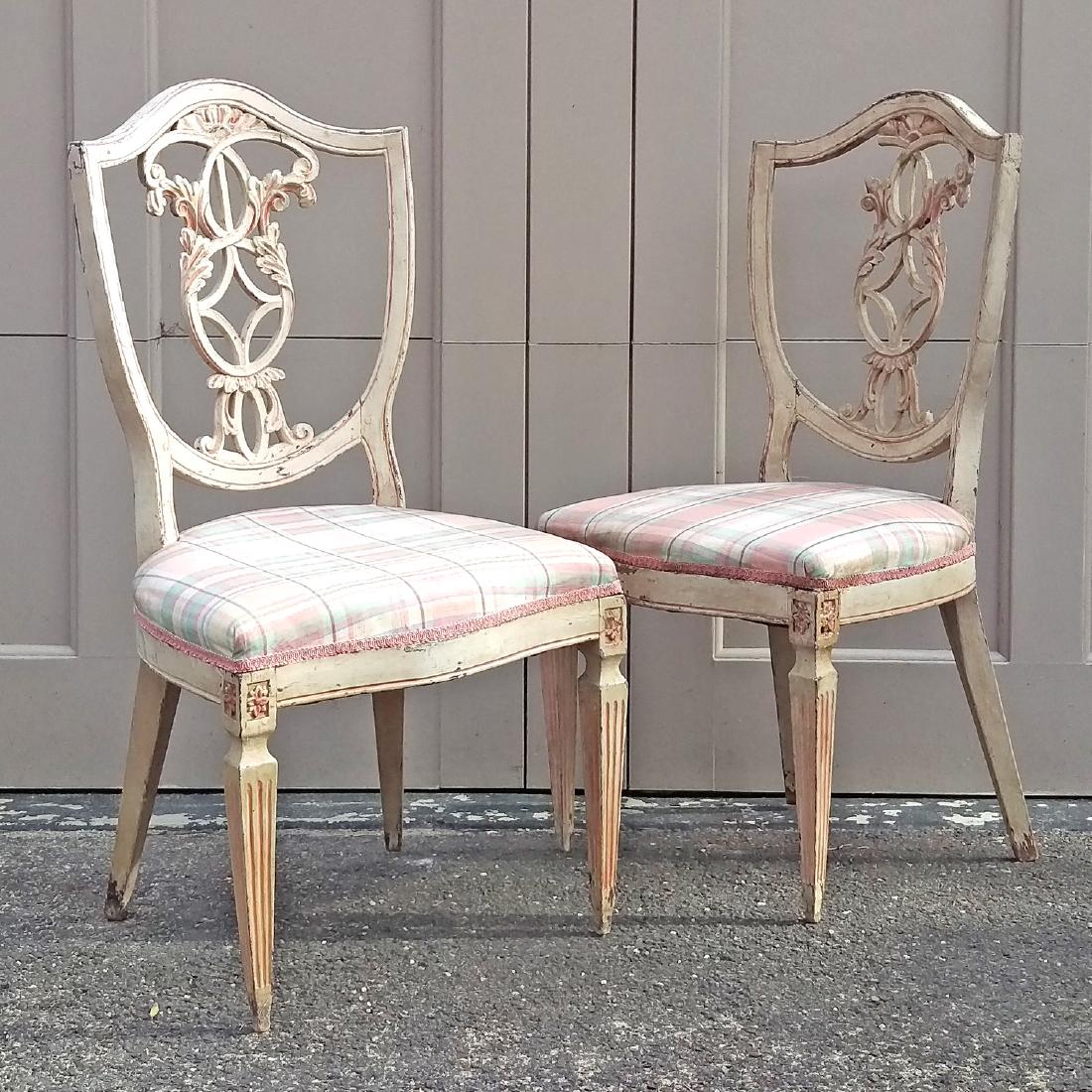 PAIR VENETIAN POLYCHROMED SHIELD BACK CHAIRS: 19th c. or Earlier, having leaf scroll splat, serpentine seat rail, square tapering fluted legs, distressed cream coloured finish with pink highlights, seat height 18â€, h. 36â€, w. 19â€ Cond