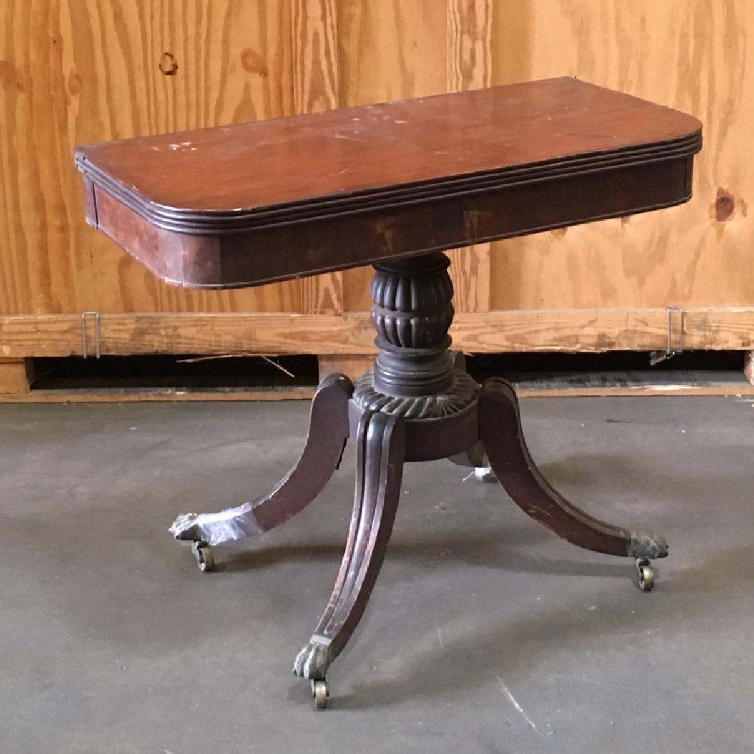 CLASSICAL FEDERAL MAHOGANY GAMES TABLE: C. 1840, mahogany pedestal swivel-top games table having bulbous gadrooned post resting on platform with four saber shaped legs terminating in cast brass claw feet on casters, h. 29-3/4 x w.36 x d.17-
