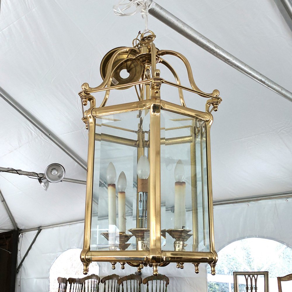 BRASS & GLASS PANELED HALL FIXTURE: Brass chain suspending a central post with six electrified candle-form lights encased in six beveled glass panels h. 31 x w. 14-1/2 in. Provenance: From a Scarsdale, NY home