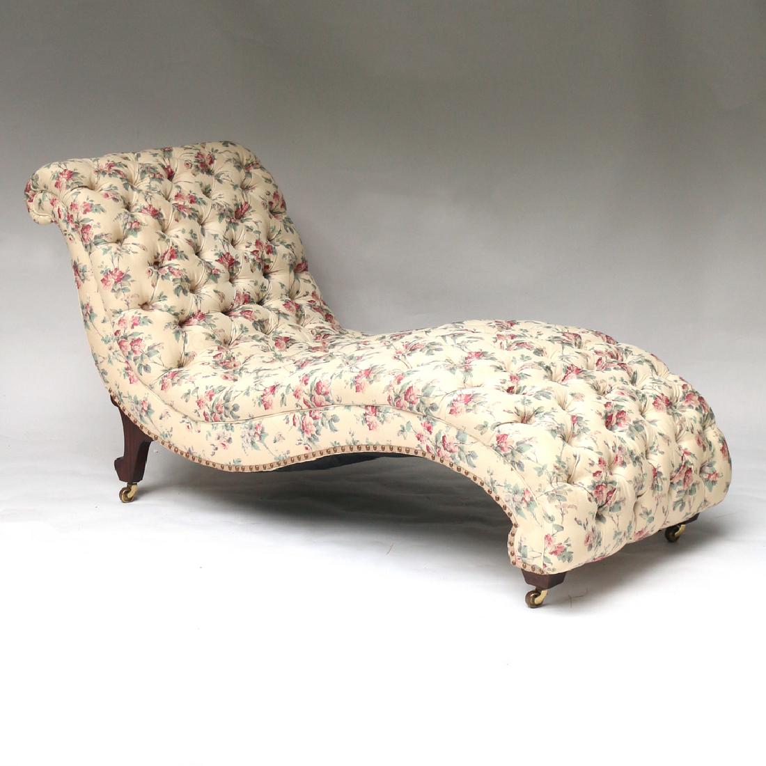 TUFTED CHAISE LOUNGE: of serpentine-shape with overall tufted floral upholstery, mahogany feet with brass casters h. 35 w. 70 d. 28 in. Condition: upholstery in good condition