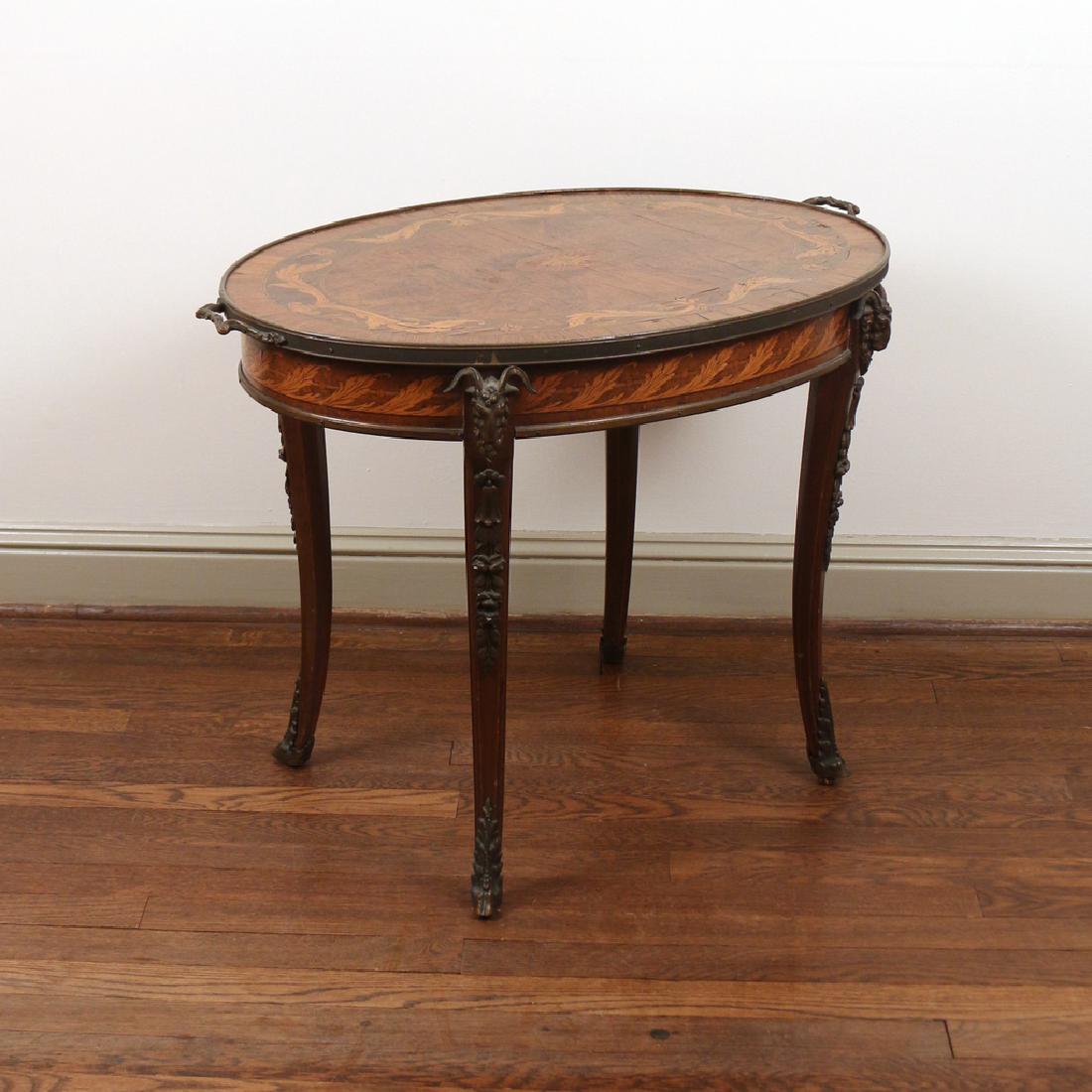LOUIS XVI-STYLE BURL WOOD OCCASIONAL TABLE: Having ormolu mounts and a tray top, saber legs with ram's head mounts h. 23 w. 30-1/2 d. 20-1/2 in. Condition: - Bottom center small leaf piece of veneer missing, the light color. -Above center medal