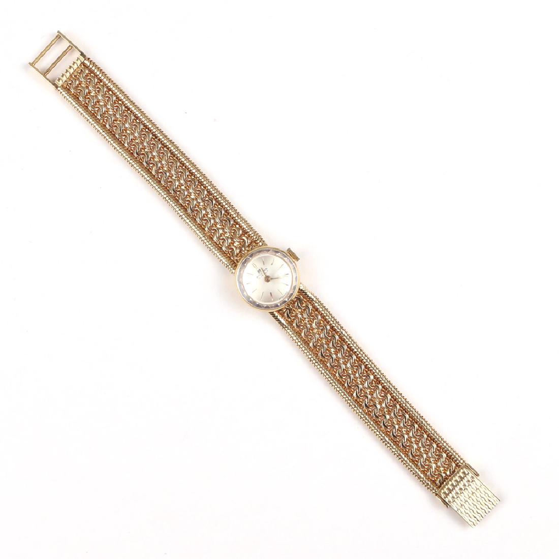 LADY'S BUCHERER GOLD WATCH: Designed as an 18k gold Bucherer watch, silver dial with baton numerals, marked 750 - 35584" conjoined double-curb link and snake bracelet; bracelet l. 7 in., 41.3g; with box"