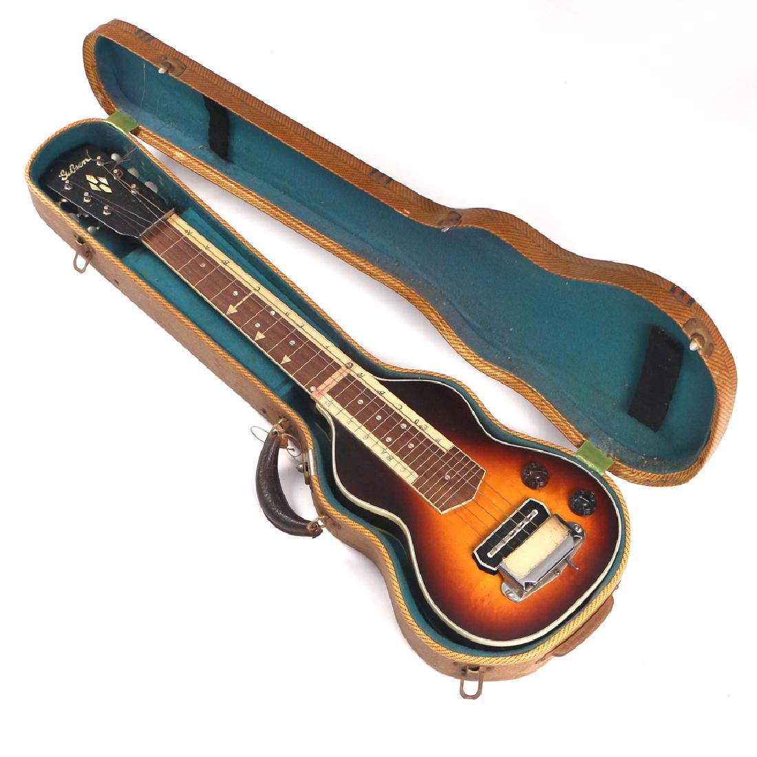 GIBSON LAP STEEL GUITAR: Serial No. FGE2112, original case, tape with learner's notes applied 19 in. (fingerboard) h. 32-1/2 w. 8-3/4 d. 3 in. overall: 33-1/2 x 11 x 4-1/2 in. (case) Provenance: Owned by the artist John Allis