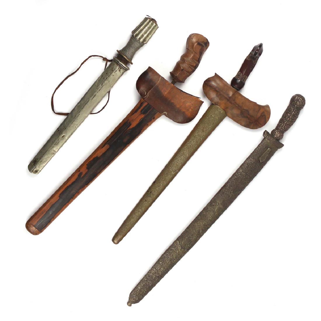 (4pc) INDONESIAN KNIVES: Including a Kris with carved wooden handle, iron blade, and wooden hilt and sheath (l. 21 in.), a Kris with carved wooden handle, iron blade, wooden hilt, and brass impressed shealth (l. 19-1/2 in.), 