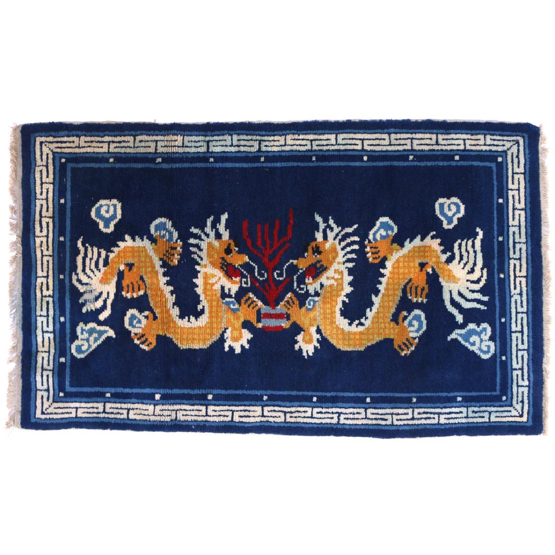 MONGOLIAN DRAGON RUG: early 20th Century, having a blue ground with two opposed dragons chasing a pearl h. 4ft-9in w. 2ft-9in