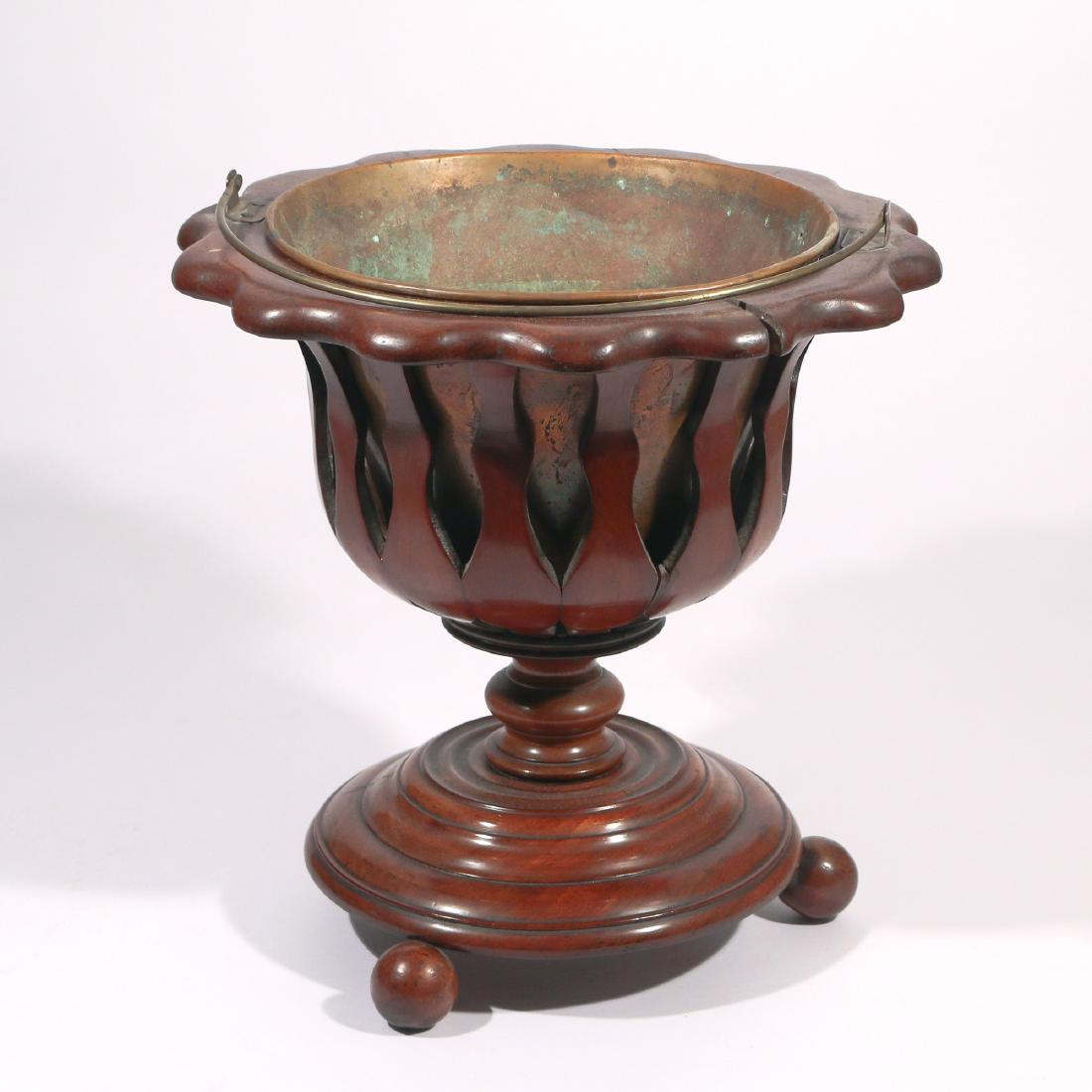 GEORGE III FOOTED PEAT BUCKET: Carved wood with openwork bucket with brass handle and liner, tapered foot with carved concentric circles and spherical feet h. 15 w. 15 in. Condition: old repair, age cracks, separations as pictured