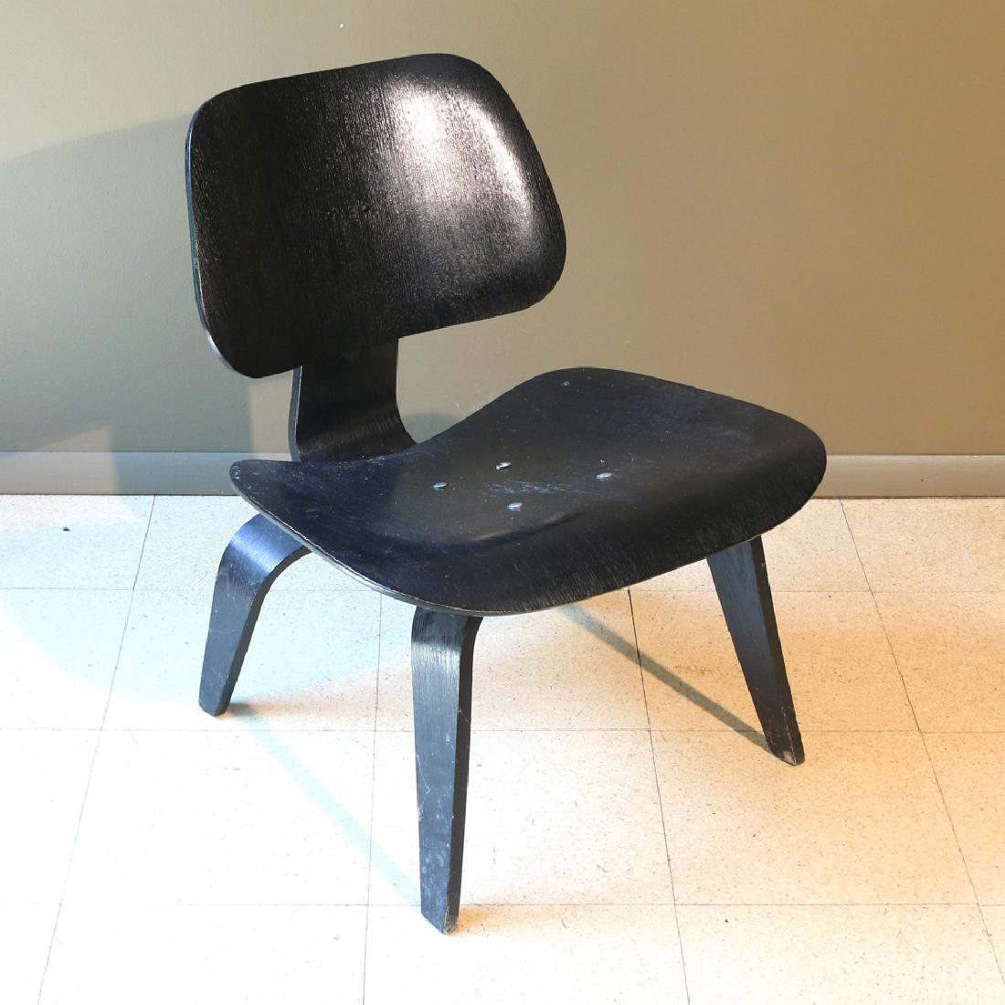 CHARLES EAMES / HERMAN MILLER LOW CHAIR: black-lacquered plywood, retailed by Herman Miller, with foil label_x000D_ AUCTION IN SITU ITEM: Please note this is available to view by appointment as it is stored externally to the saleroom h. 27 w