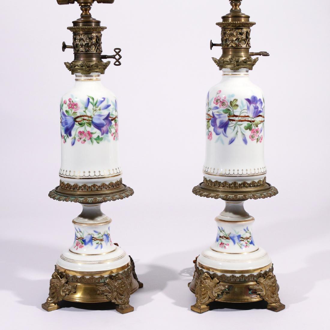 PAIR SEVRES STYLE PORCELAIN VASES: painted with purple and pink flowers, ormolu mounts, electrified as lamps h. 19 w. 7 overall: 29-1/4 (with glass shade) Condition: one with flake to upper lip of lower section