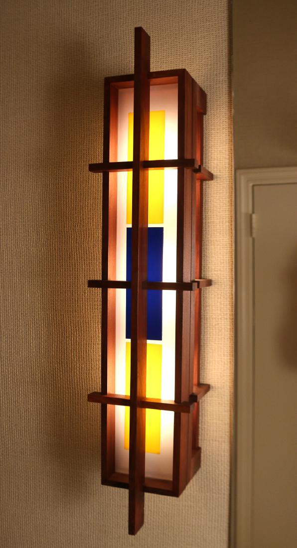 MID-CENTURY WALNUT WALL SCONCE: of rectilinear design with yellow and blue panes, fixtures marked 'Leviton' h. 32 w. 7 d. 6.5 in.
