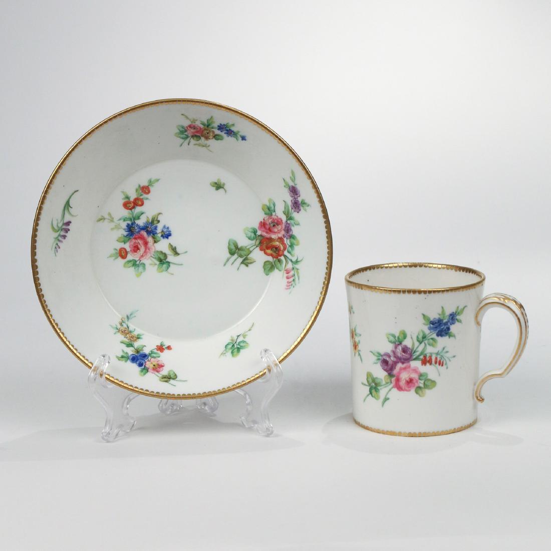 VINCENNES PORCELAIN CUP AND SAUCER: Circa 1750, painted with floral bouquets on a white ground, with interlacing L marks h. 3 in. (cup) dia. 5-3/4 in. (saucer) Provenance: Estate of John F. Ball, Television and Film Production Executive