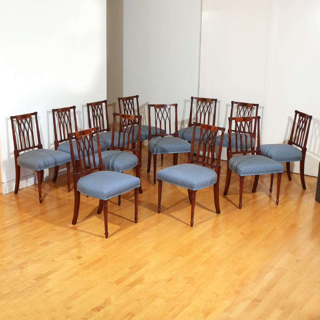 (12pc) HEPPLEWHITE-STYLE INLAID MAHOGANY CHAIRS: 20th Century, with reeded crests centered by inlaid rectangular panels above ogival splats and reeded stiles with feather-carved capitals, blue upholstered seats and reeded legs ending in peg feet h. 