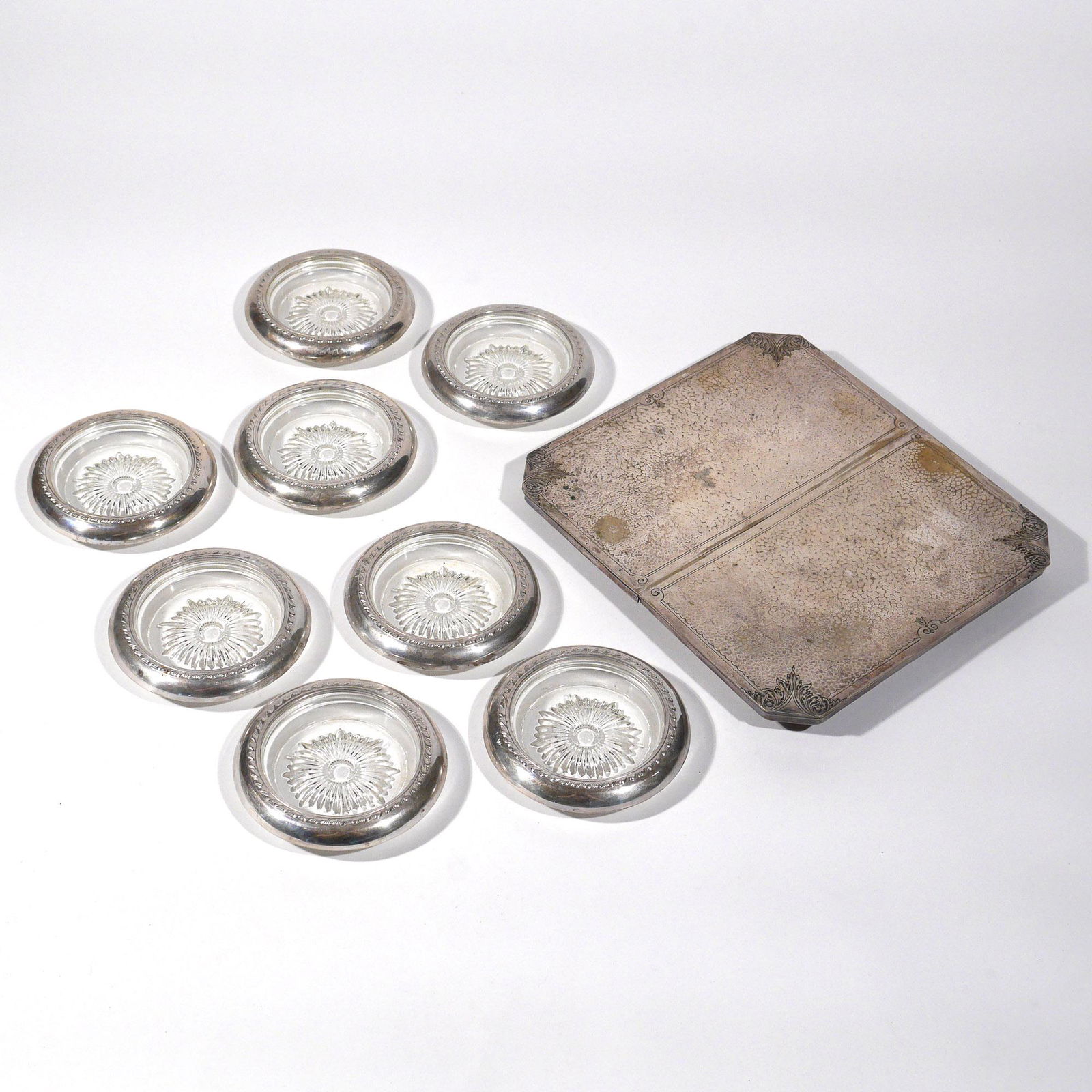 (9pc) SILVERPLATE ITEMS: Including a Sheffield hammered expanding trivet (9 x 8-1/4 in.), and 8 sterling silver collared glass coasters (4 in.) marked "sterling"