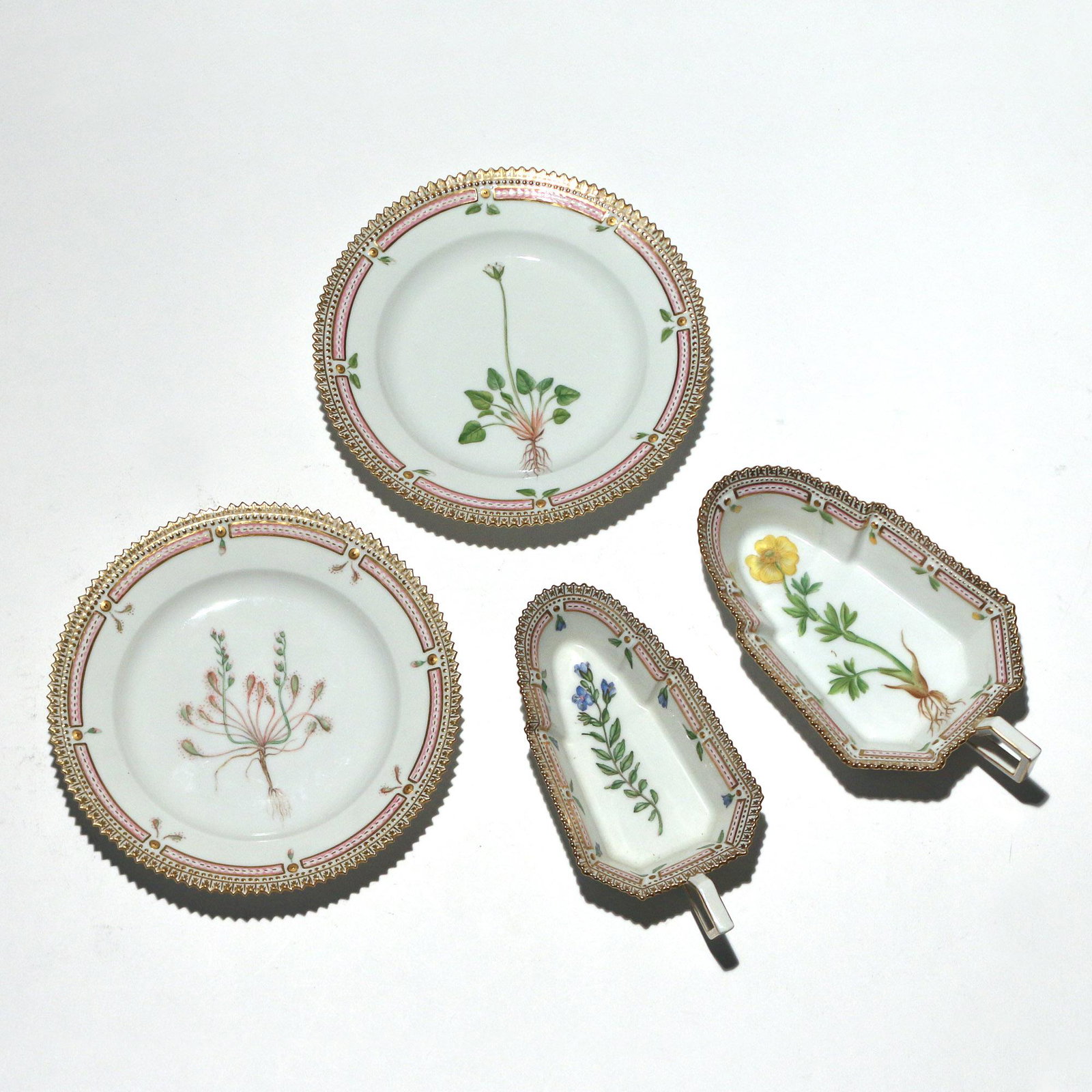 (4pc) ROYAL COPENHAGEN FLORA DANICA PORCELAIN: including two pickle / relish dishes ('veronica fruticulosa' and 'potentilla hirsuta vahl'), and a pair of bread plates (Drosera intermedia Hayne' and 'Parnassia Kotzebuei Cham & Schladl.' dia. 6-3/4 