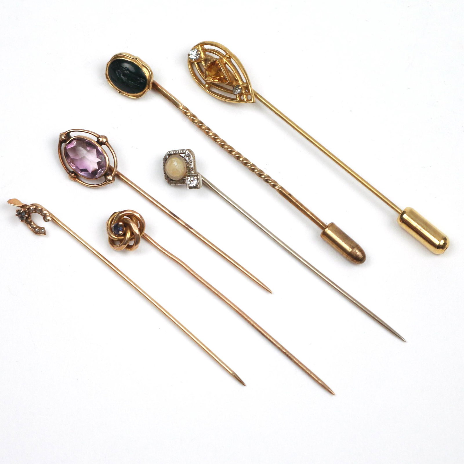 (6pc) GOLD STICK PINS: mostly tested as 14k gold, including a pin with an openwork gallery with citrine and diamonds (1.7g), a pin with blue sapphire (1.6g), a pin with green stone intaglio (2.4g), a pin with oval amethyst 