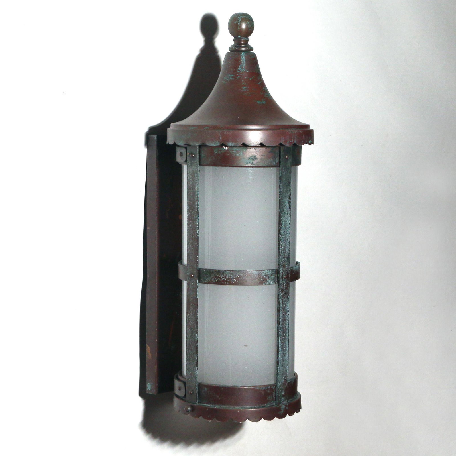 ARTS & CRAFTS COPPER EXTERIOR WALL SCONCE: early 20th Century, with ball finial over a sloped cap and a cylindrical milk glass shade with cross bars, shaped apron h. 20 w. 7 d. 8 in.