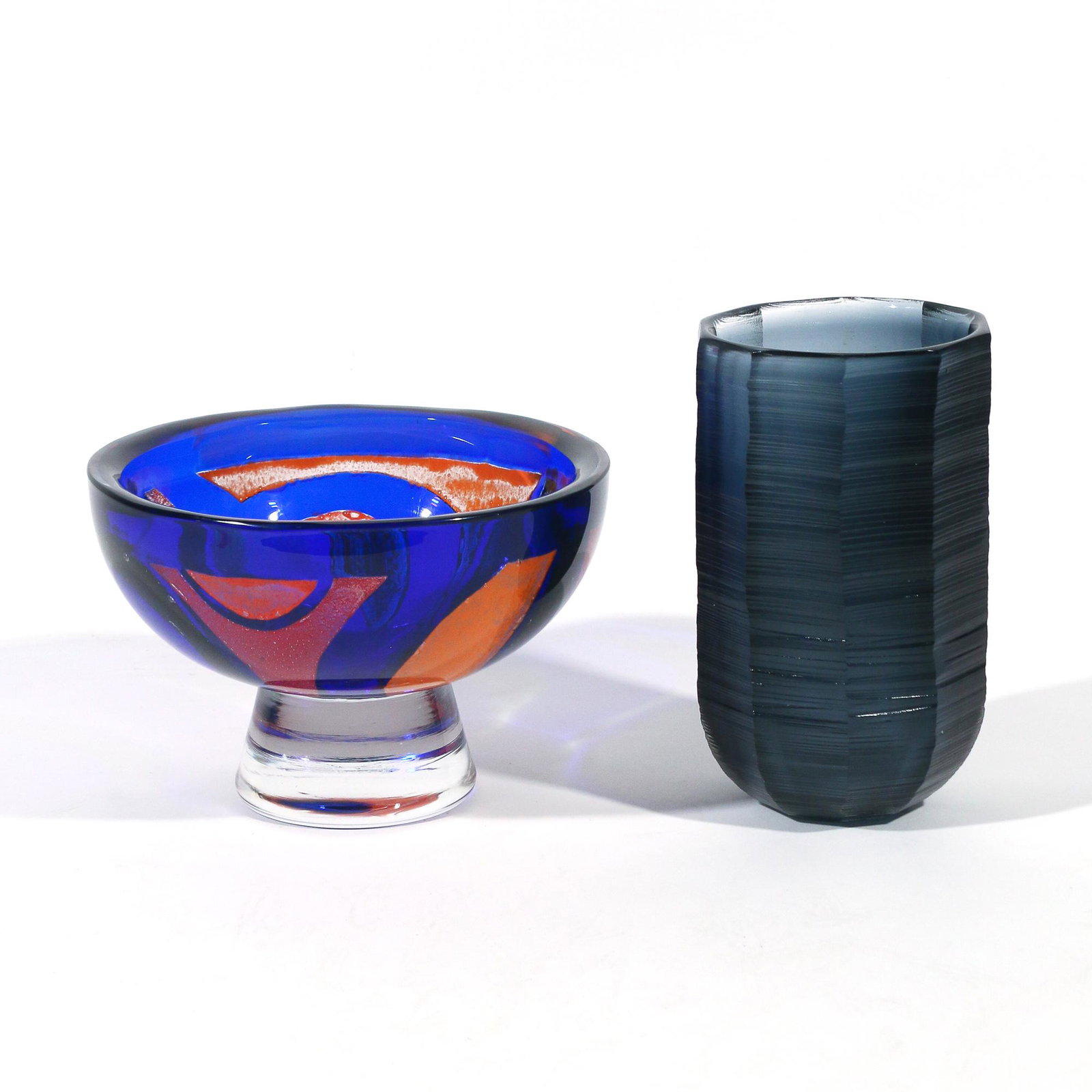 (2pc) JAN JOHANSSON (b. 1942), ORREFORS EXPO: including a blown blue and orange glass bowl with geometric pattern, base signed "ORREFORS / Expo 359-74 / Jan Johansson" (h. 5-5/8 x dia. 8-5/8 in.), and a blown grey wheel-engraved faceted glass vas
