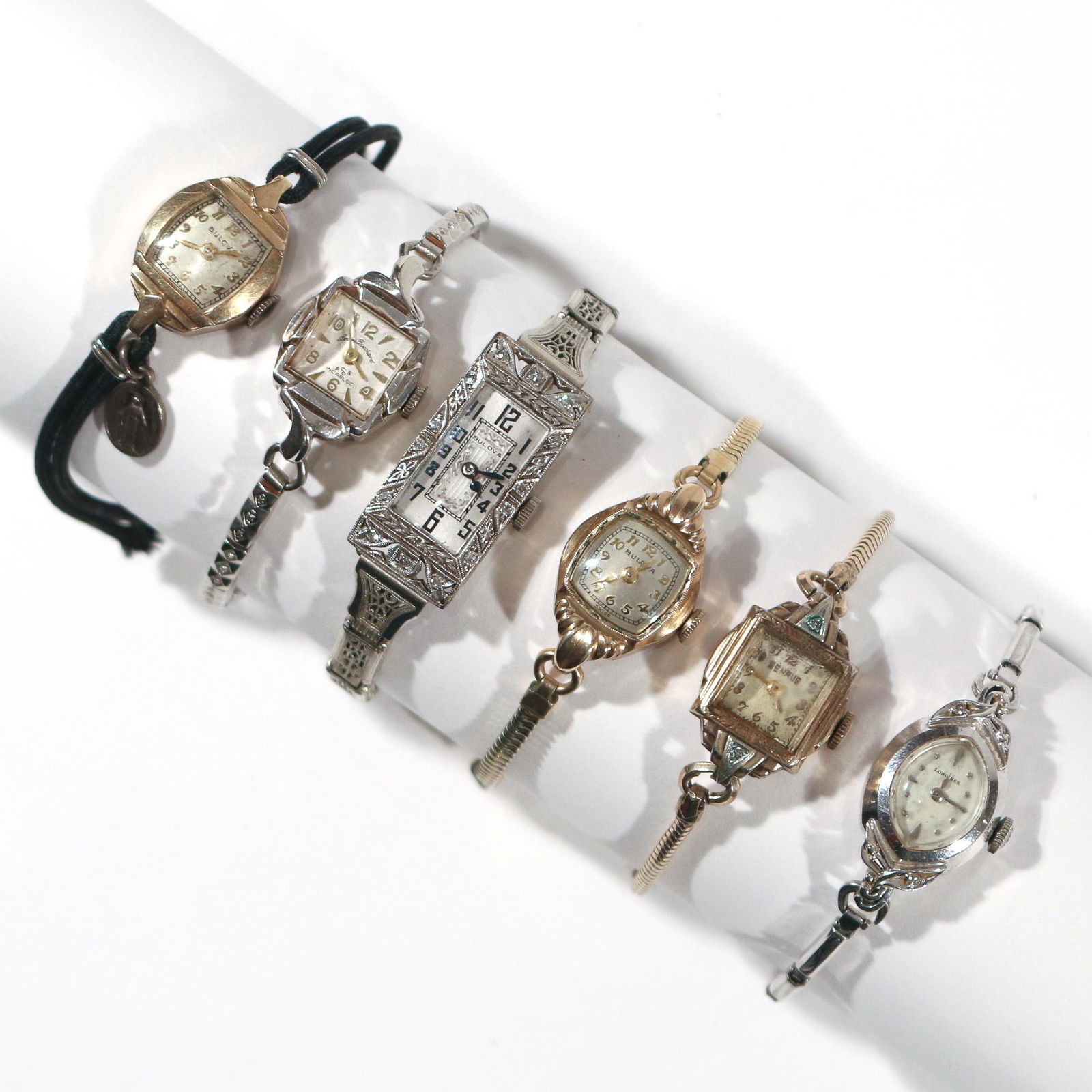 (6pc) LADY'S DESIGNER WRISTWATCHES: Including a Bulova square watch in an 18k white gold "S Bruner" case with engraved bezel mounting 14 melee diamonds, on an 18k gold-filled Simmons Patent bracelet, Swiss 15 jewel "Glamour Watch" movem