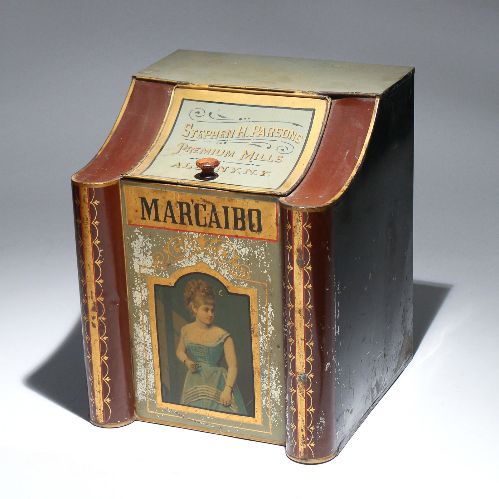 ALBANY N.Y. MAR'CAIBO TOBACCO TIN: late 19th Century, the tin with curved top and door reading 'Stephen H. Parsons / Premium Mills / Albany, N.Y.', the front inscribed 'Mar'caibo' and with a portrait of a young woman h. 14 w. 11-1/2 d.