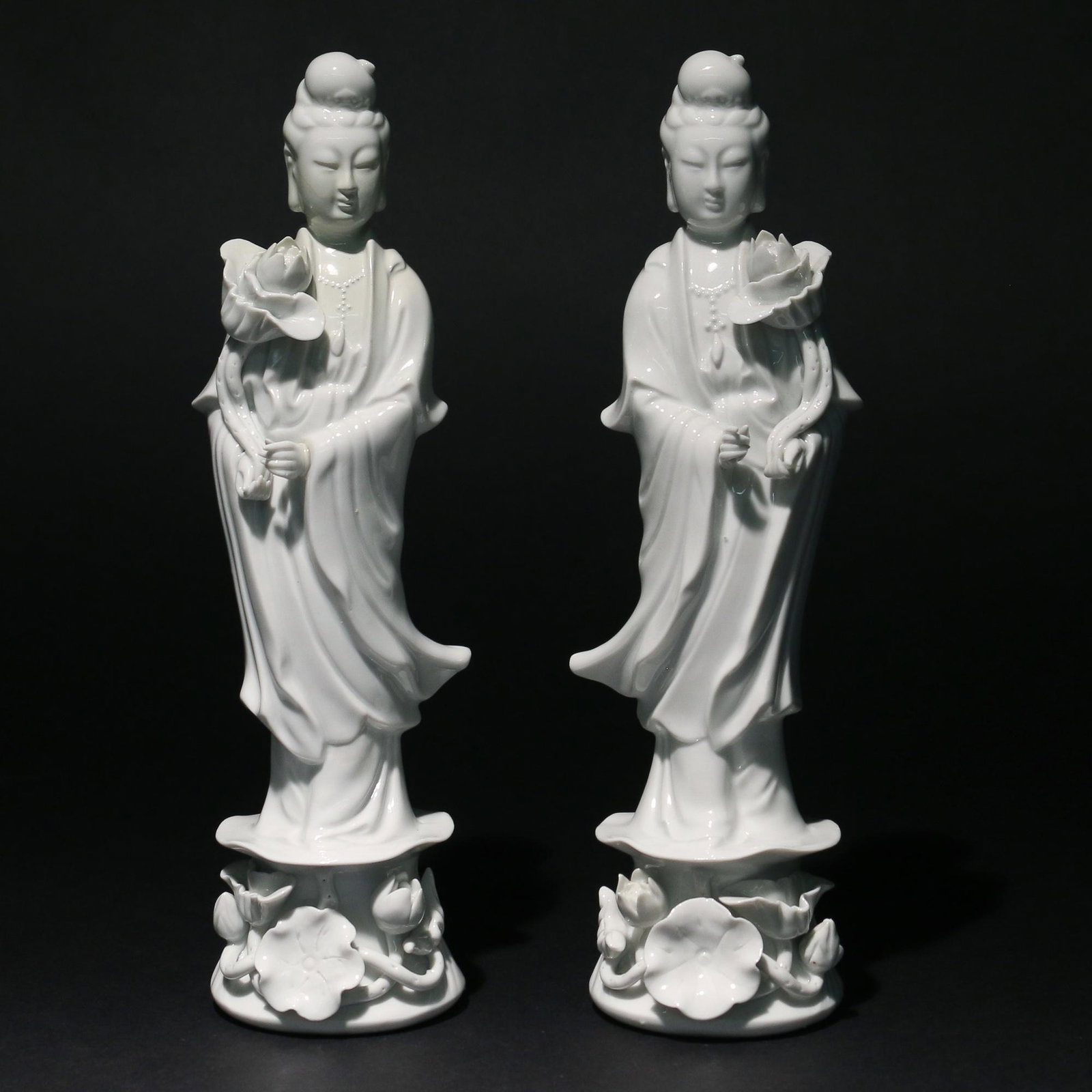 PAIR BLANC-DE-CHINE QUAN YIN FIGURES: mirrored pair, each holding a blooming lotus flower and standing upon a viney plinth h. 9-3/4 dia. 2-5/8 in. Provenance: from the estate of a celebrated gemologist, jade & Asian art collector, Philade