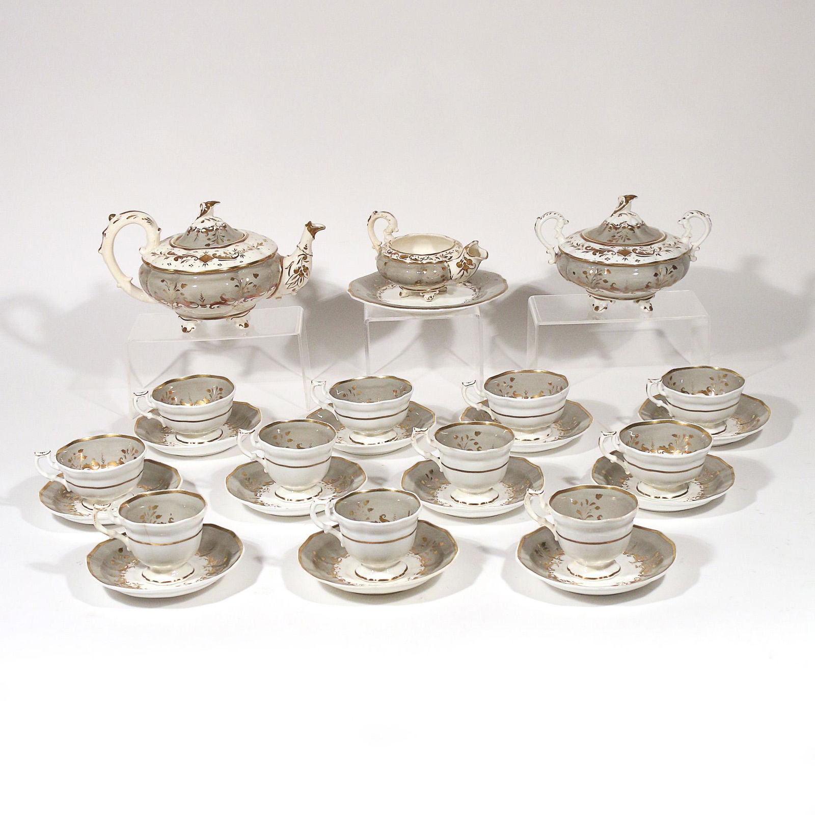 (26pc) PAINTED PORCELAIN TEA SET: white and grey painted porcelain tea set with gold leafing, including a teapot, creamer with under plate, and covered sugar bowl; plus 11 cup and saucer sets; some pieces marked "229" on underside h.