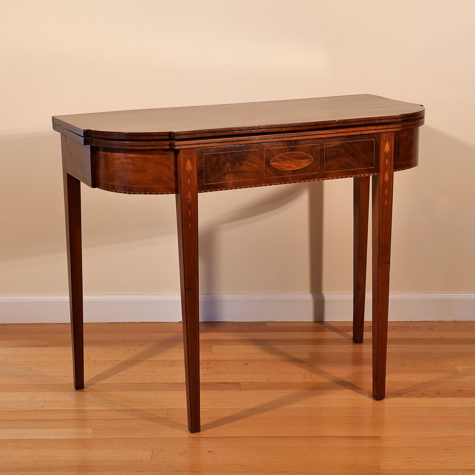 INLAID GAMES TABLE: 19th century, solid top with finely inlaid banding and with bellflower motif, standing on square tapering legs h. 29 w. 35-3/4 d. 17-1/2 in. Provenance: items descended through the families of a Green