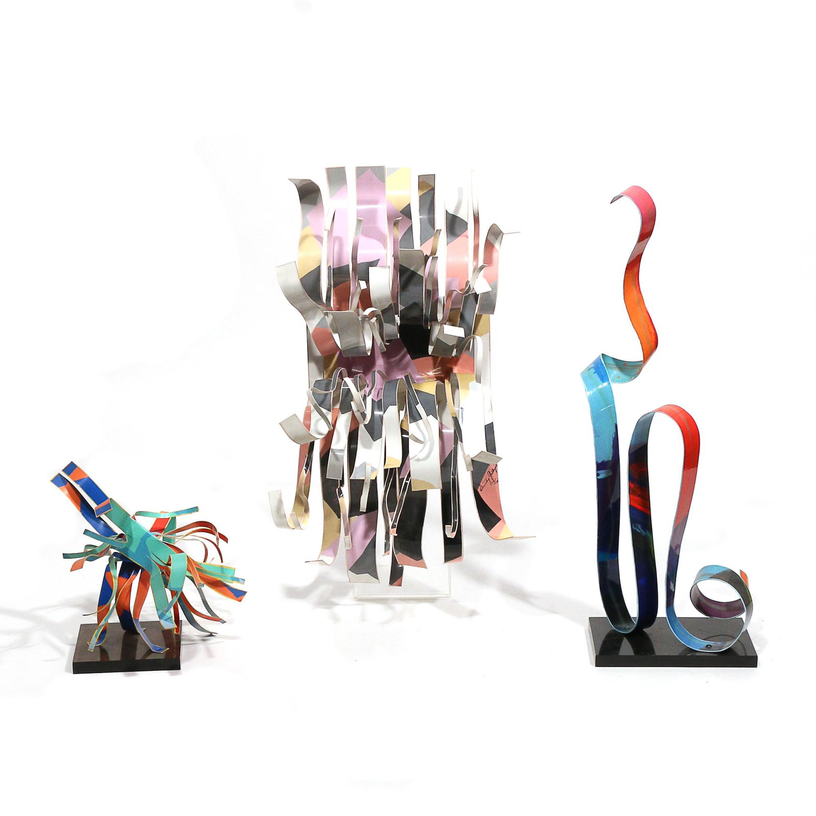 (3pc) DOROTHY GILLESPIE (American, 1920-2012): enamel on aluminum Ribbon-form sculptures, each signed; including one on a square base, designed as a formed single piece decorated in primarily orange, blue, green, and red enamel, ed. 47/99 (h. 6-7/