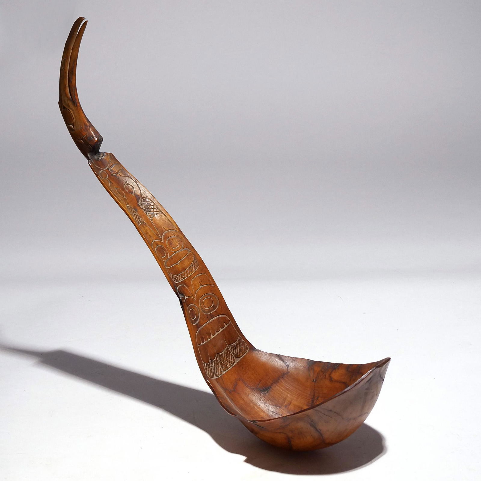 LARGE PACIFIC NORTHWEST CARVED FEAST LADLE: Second half of the 19th century, a very fine, large and rare Haida or Tlingit ceremonial feast spoon or ladle, carved from mountain sheep horn that has been steamed and bent into shape, the handle inc