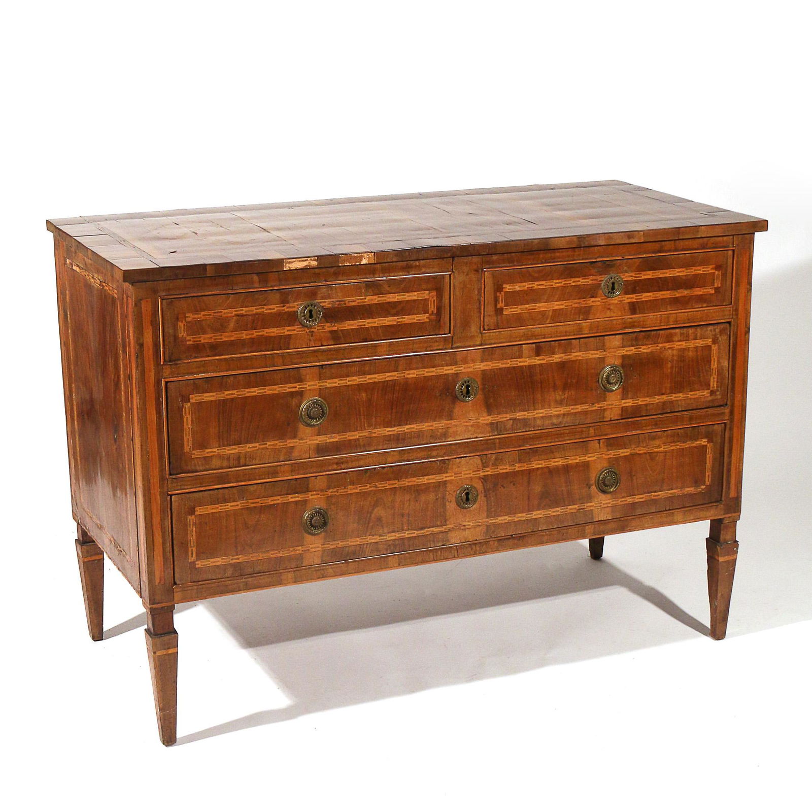 ITALIAN NEOCLASSICAL INLAID OLIVEWOOD COMMODE: 19th century, inlaid in various fruitwoods; having two short drawers over two full-width drawers, raised on square tapering feet h. 34 w. 49 d. 23 in.