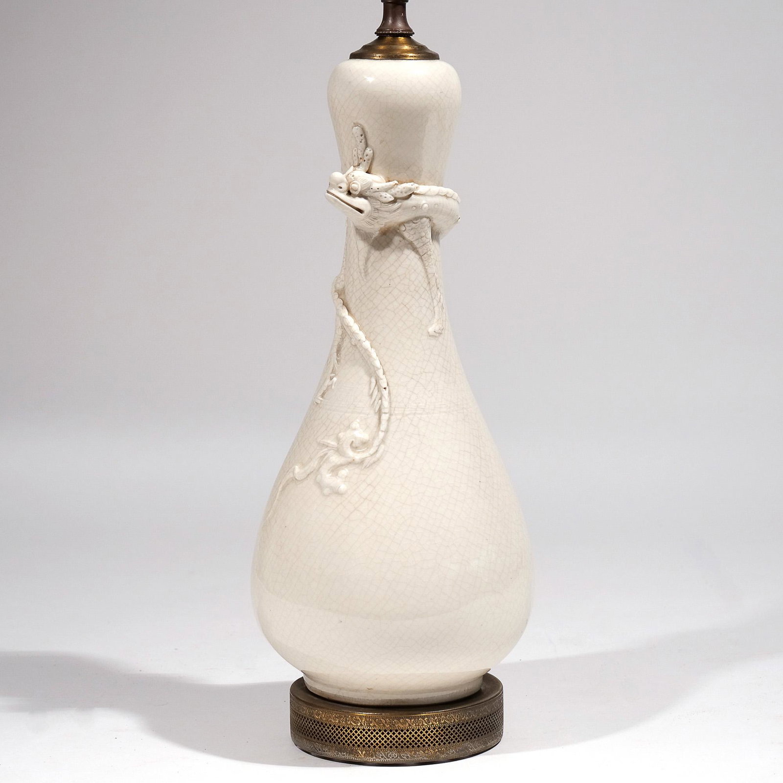 CHINESE DEHUA PORCELAIN LAMP: 19th century, bottle shape with an applied sinuous dragon around the neck h. 12-1/2 w. 6 in. (porcelain) overall: h. 27 in. (over harp) Provenance: Alva Gimbel, Greenwich, CT; then by descent to curre