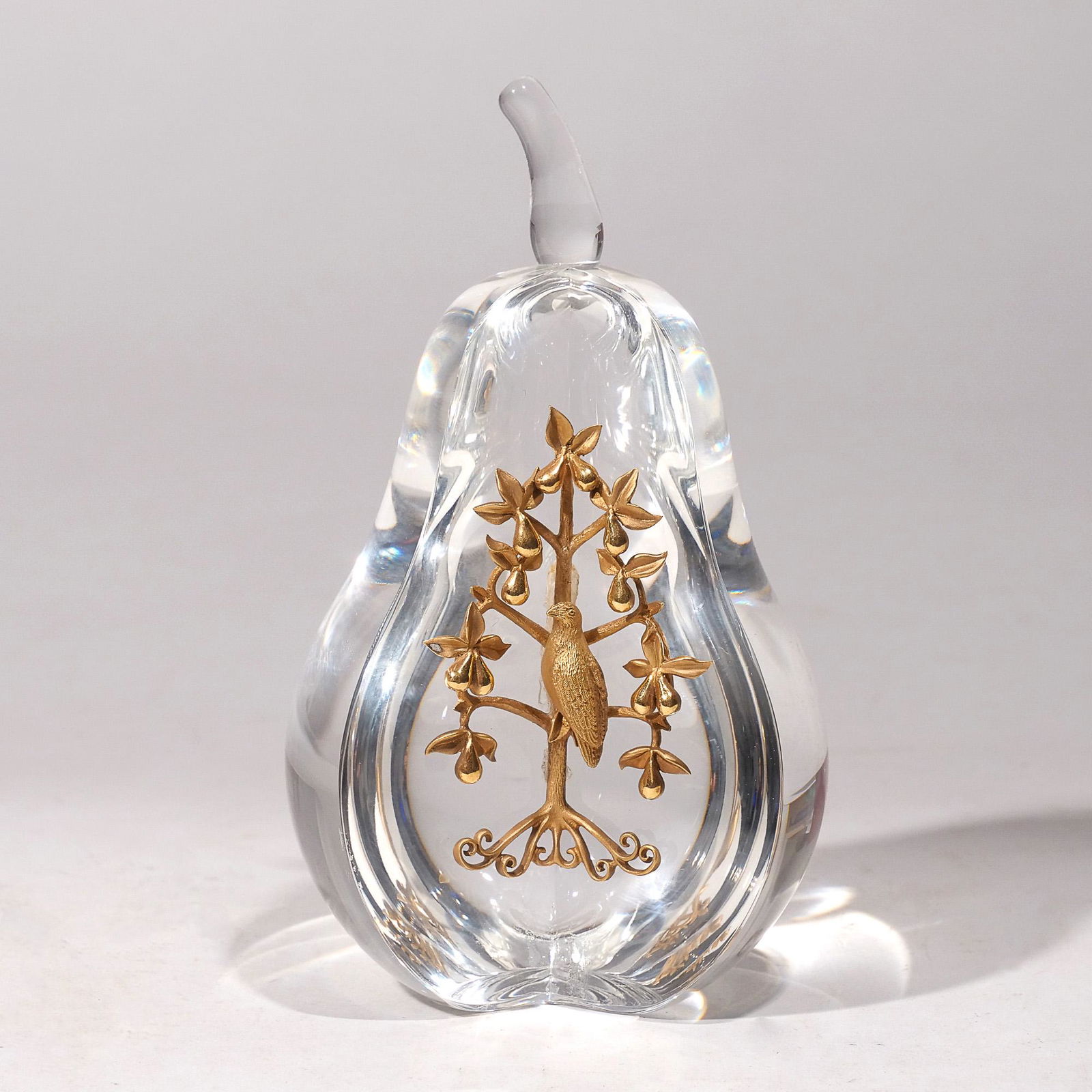 STEUBEN 18k PARTRIDGE & GLASS PEAR: Designed as a crystal glass pear signed on the base mounting an 18k gold chased partridge (weighing 58.1g) perched among pear branches; in a fitted red Steuben box h. 6 dia. 4 in. overall: 5-1/2 x 9 x