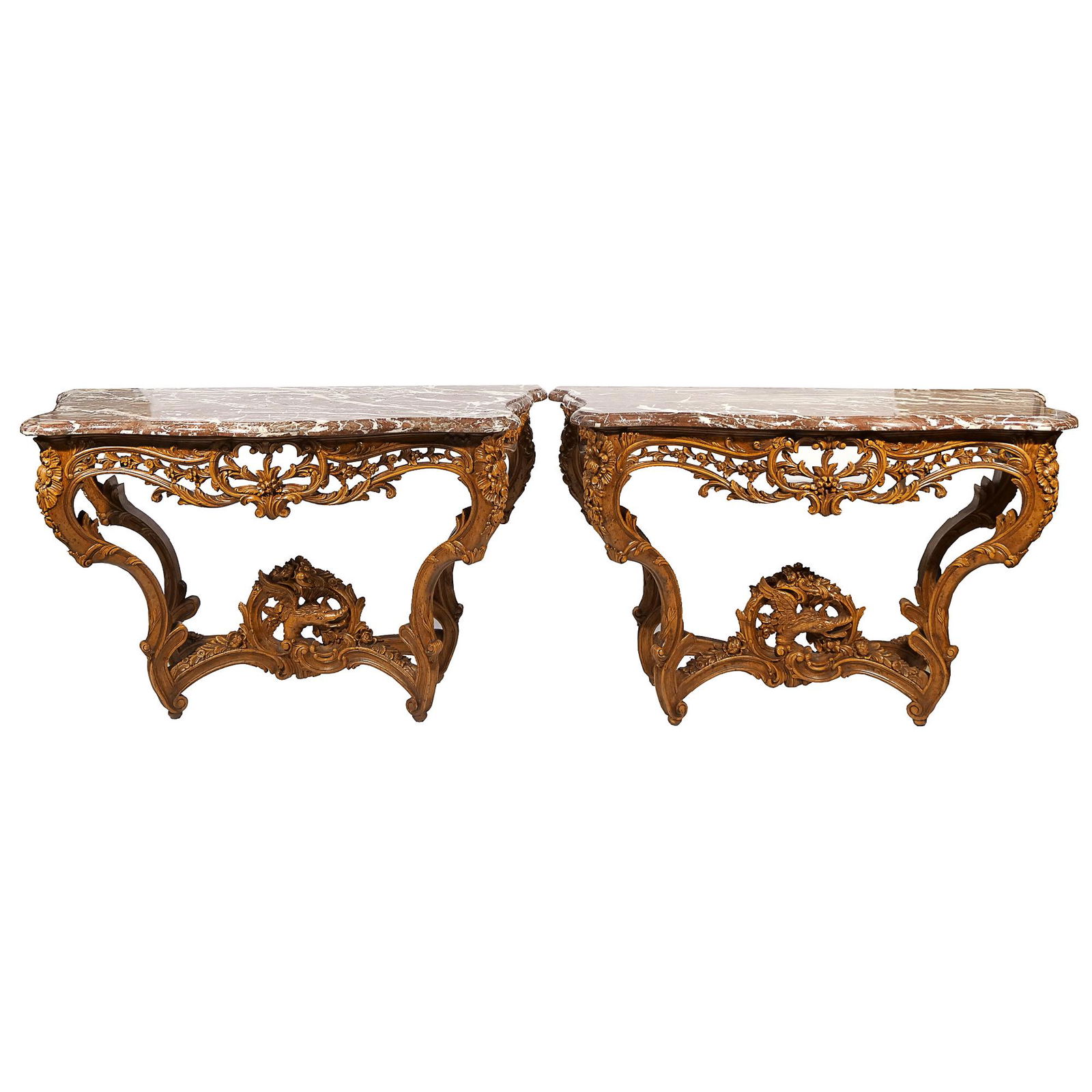 PAIR ITALIAN ROCOCO-STYLE CONSOLE TABLES: late 19th/early 20th Century, with conforming marble tops on highly carved walnut bases with classical designs of flowers and scrolling foliage, each with a cross stretcher having a central carving of
