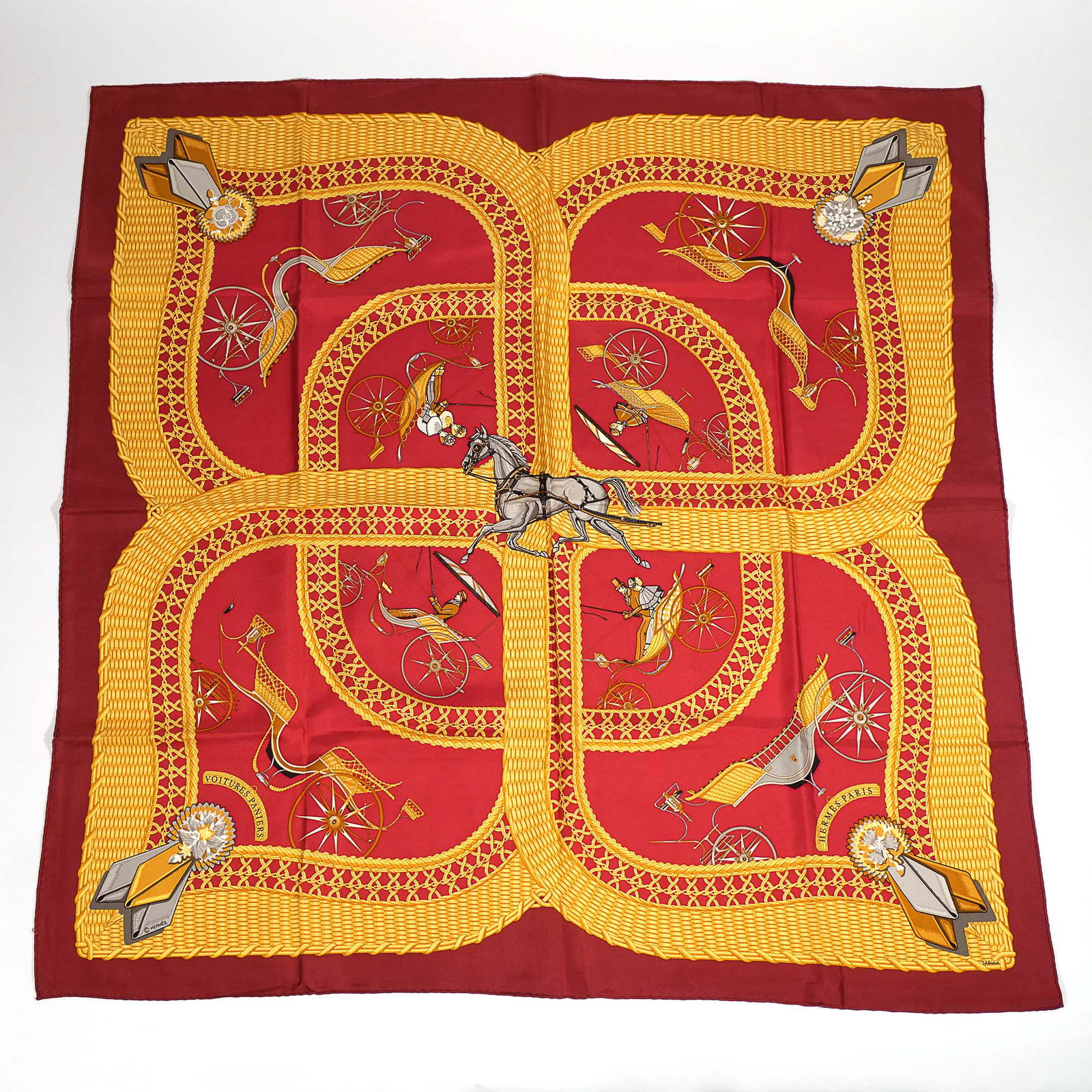 HERMES JULIA ABADIE SILK SCARF: 100% silk Hermes scarf in "Voitures Paniers" pattern, designed by Julia Abadie, on a light burgundy/deep pink ground h. 34 w. 34 in. Limited Preview: Please note that this auction has a limited in-per