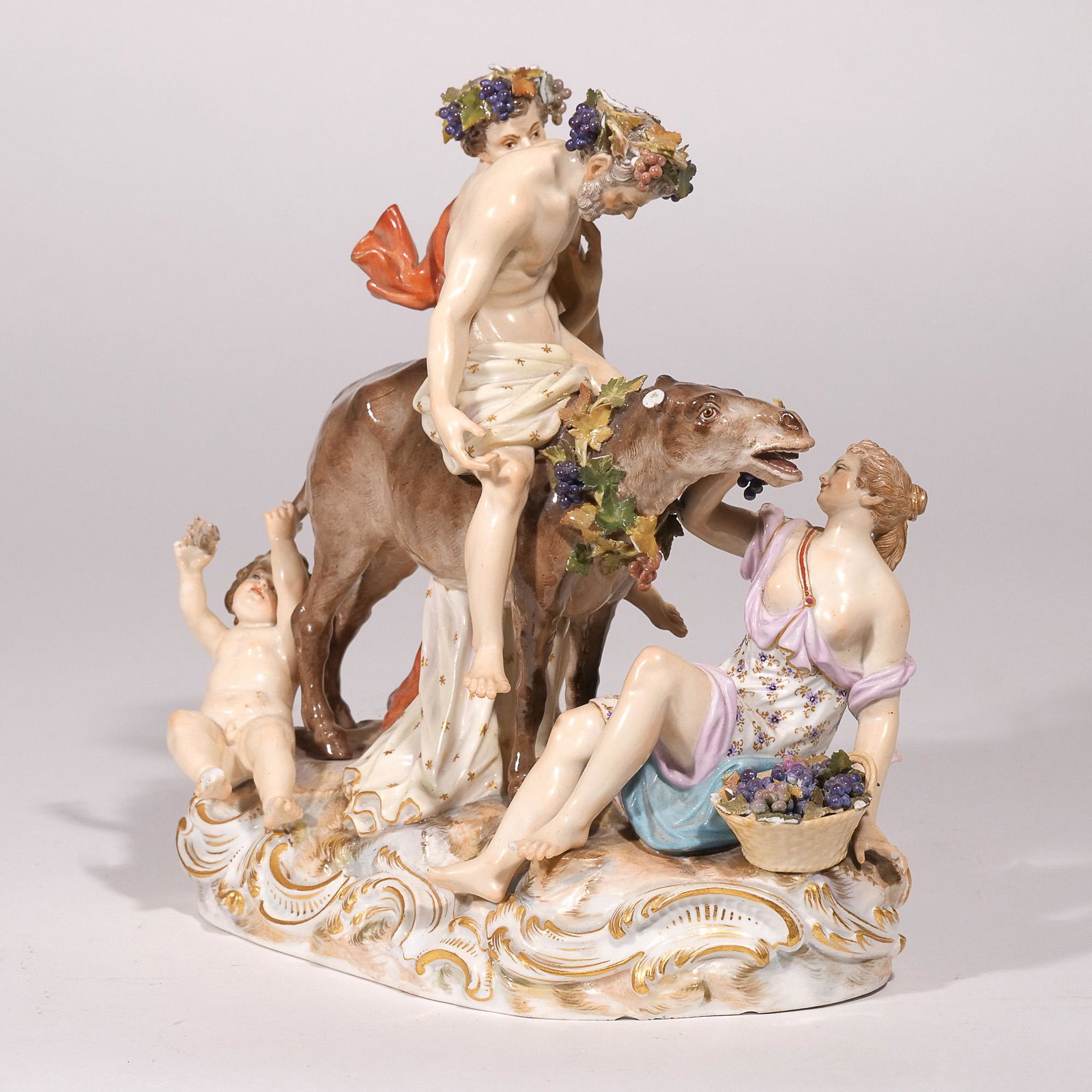 MEISSEN PORCELAIN BACCHUS GROUP: Showing a drunk Bacchus on a donkey, surrounded by his followers and a putti at the rear, all on a gilt-highlighted base; with underglaze blue crossed swords, incised with "2724" and stamped "147" h. 