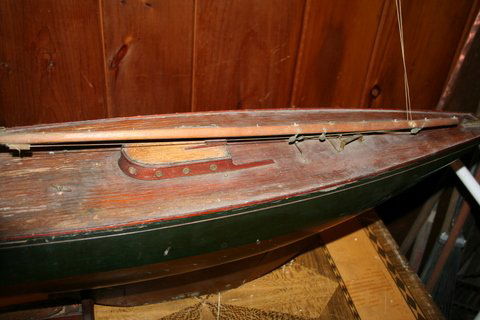362) EARLY 20C. POND BOAT W/STAND & OLD PAINT, L.44 ½",: W. 8-1/2", D. 11-1/2", FROM KEEL TO DECK, HEIGHT OF MAST 63-1/2", OVERALL H. 74"; WATER DAMAGE TO DECK, RIGGING, NO SAILS