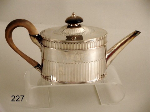 227) GEORGE III SILVER TEAPOT BY JOHN WAKELIN & : WM. TAYLOR, CIRCA1783-4, OIL CAN-SHAPE W/WOODEN FINIAL & HANDLE, STR. GADROONING ON LID & BODY, CLEAR MKS. ON UNDERSIDE, ARMORIAL DEVICE: ½ FISH W/LAURELLING, L. 11", H. 5 ½" OVER FINIAL, APPROX. 18