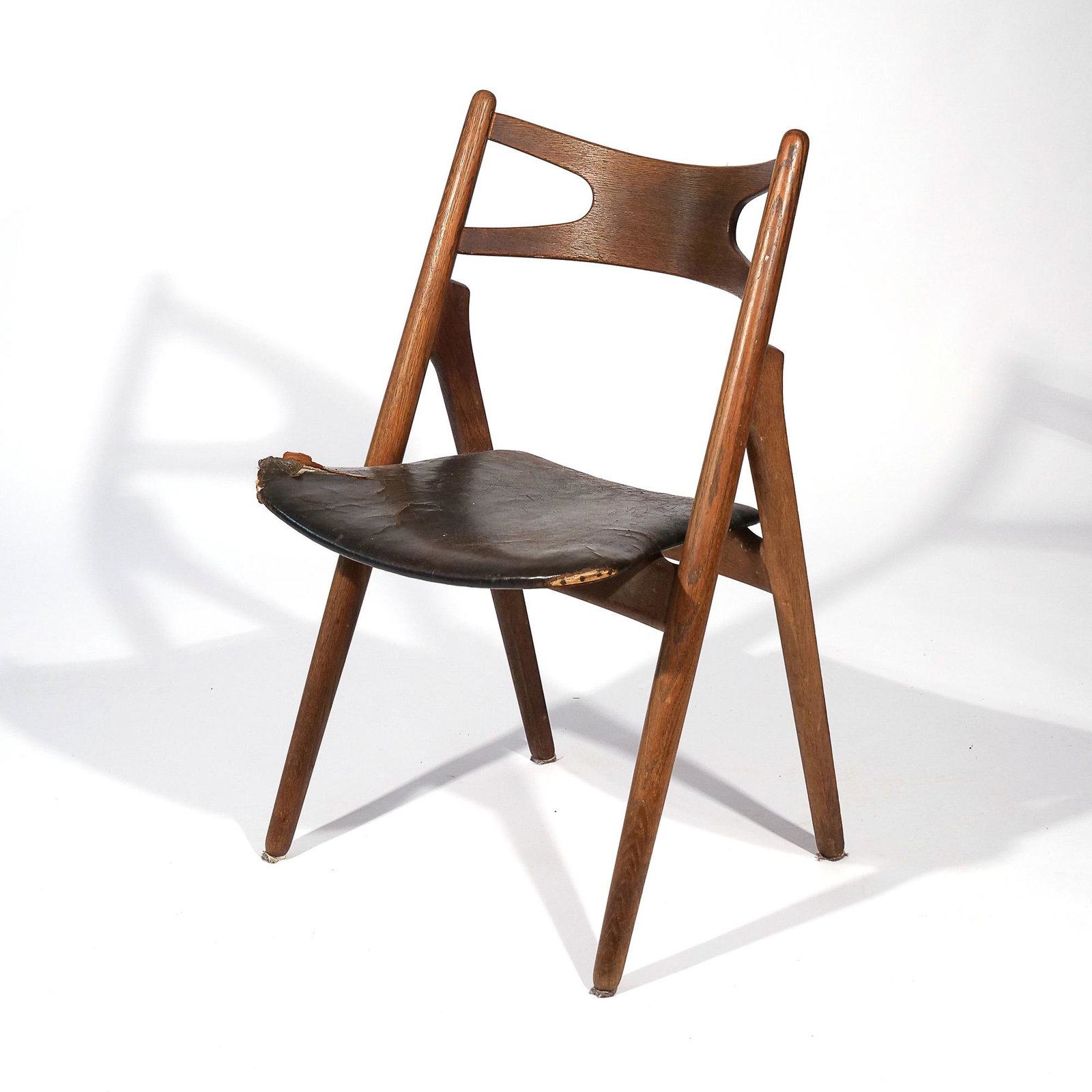 HANS J. WEGNER "SAWBUCK" CHAIR: Bent wood backrest on a carved frame, leather seat h. 32 w. 20 d. 16 in. Provenance: Descended through a South Salem, NY family [In Situ Item] This item will not be on display in our saleroom during o