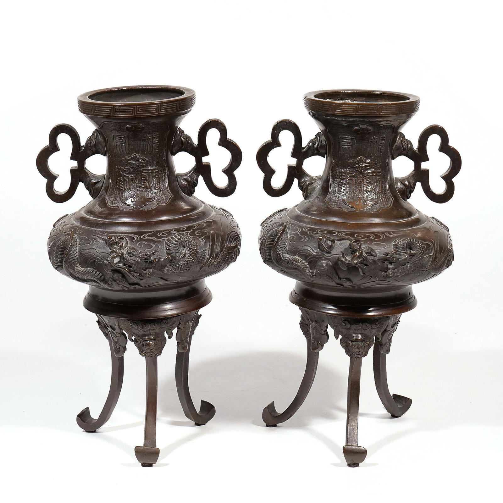 PAIR JAPANESE BRONZE CENSERS: Open censers, each with a raised dragon on one side and a phoenix on the other, with four character mark in reserve, on three splayed legs h. 12-1/4 dia. 7-1/2 in. Provenance: Collection of a New Cana