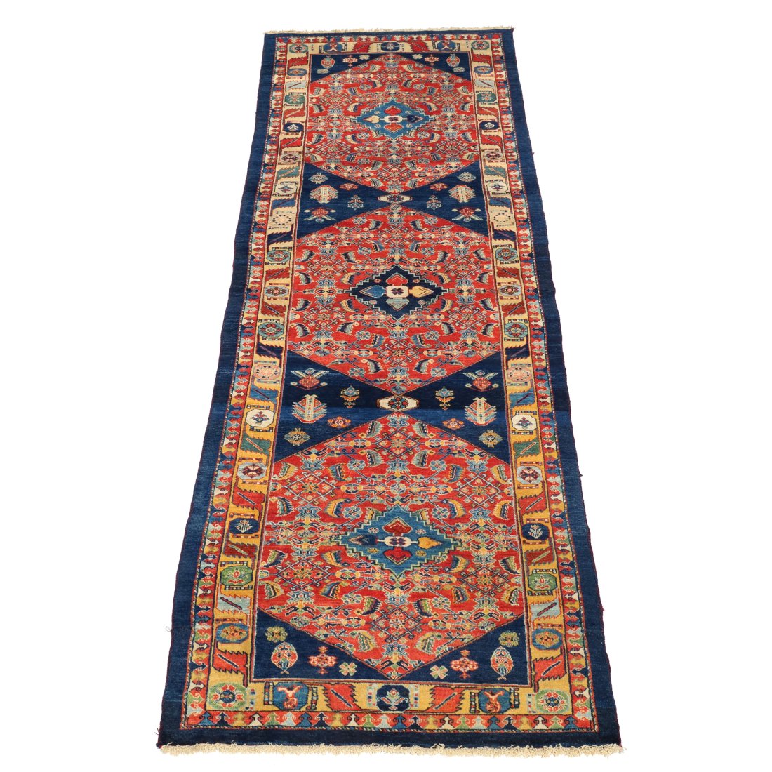 CAUCASIAN CORRIDOR RUG: With three medallions on a red field, within patterned yellow, blue, and red borders h. 12 ft. w. 3 ft. Provenance: From the estate of the late Joan E. Black, Bronxville, NY n.b. Not all items are on 